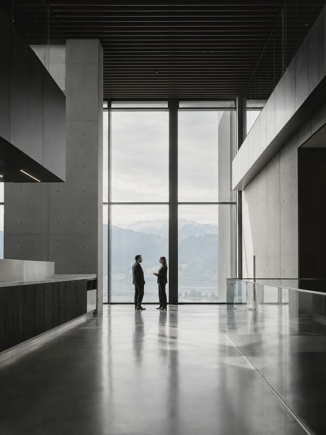 Mitarbeitende im Gespräch im lichtdurchfluteten Atrium des Neosilk Hauptsitzes in Zug